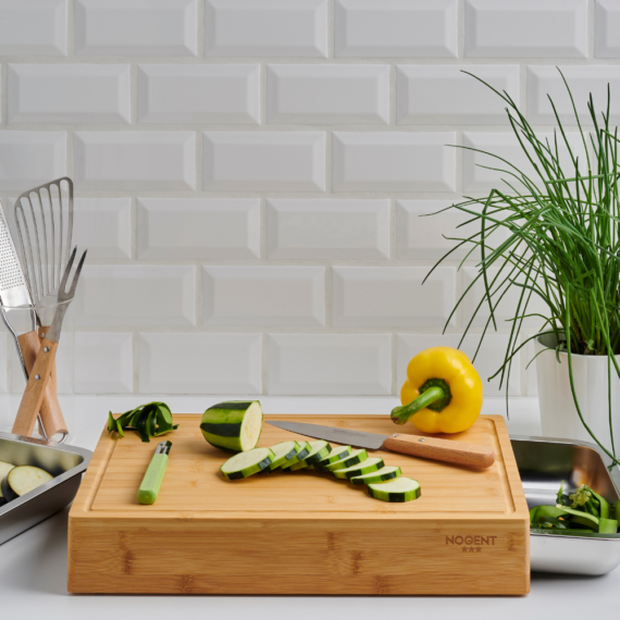 planche à découper avec tiroirs dans une cuisine avec un poivron et une courgette et des ustensile de cuisine